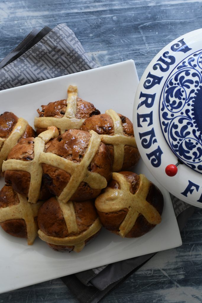 Glazed hot cross buns on a decorated plate