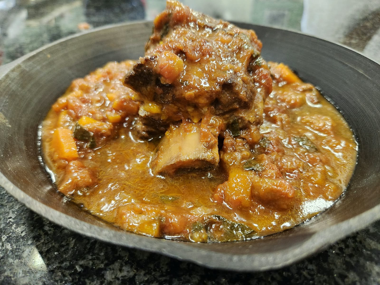 Slow-cooked beef short rib on the bone in a rich tomato sauce