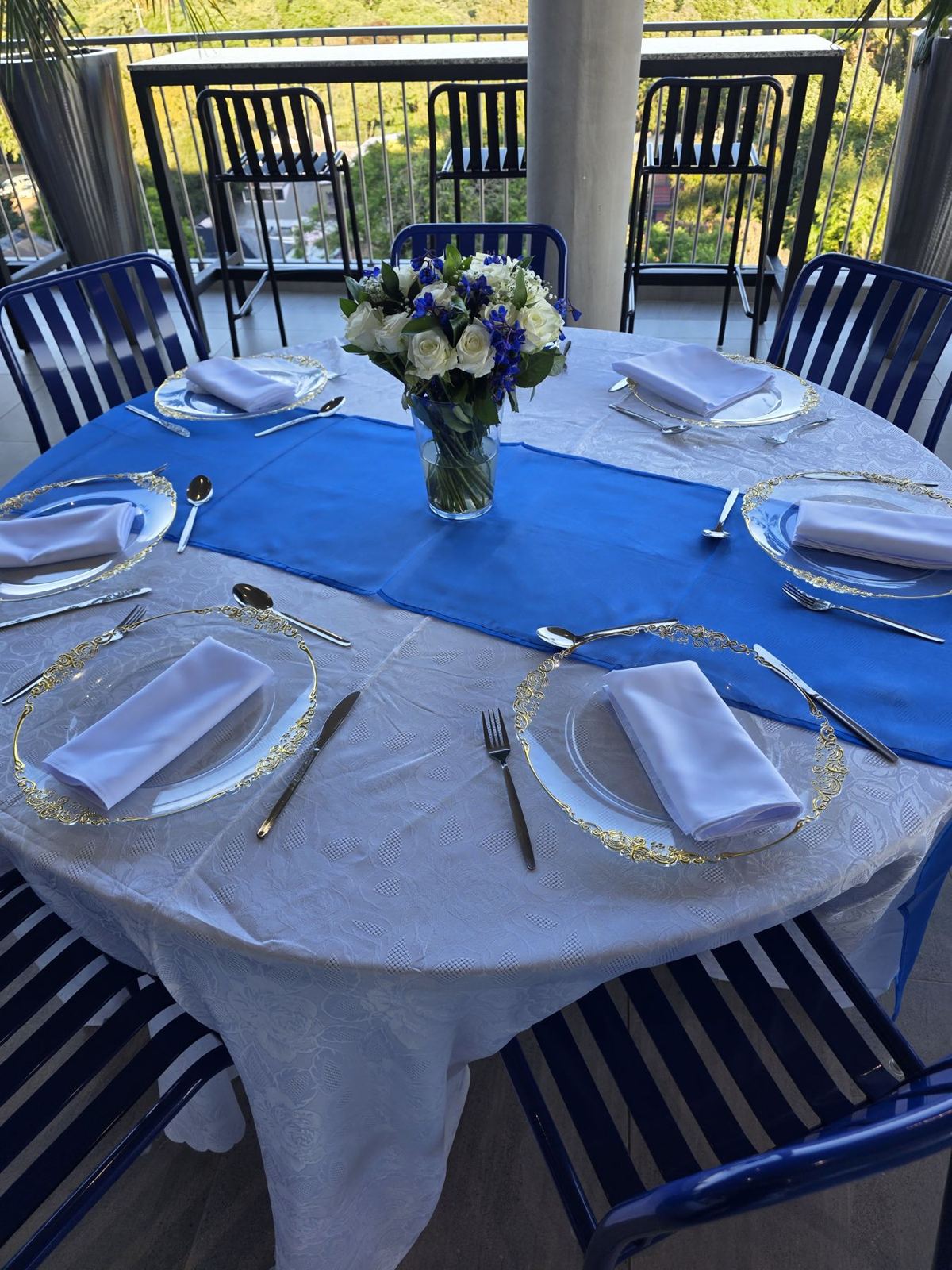 A dressed round table with blue runner and flowers