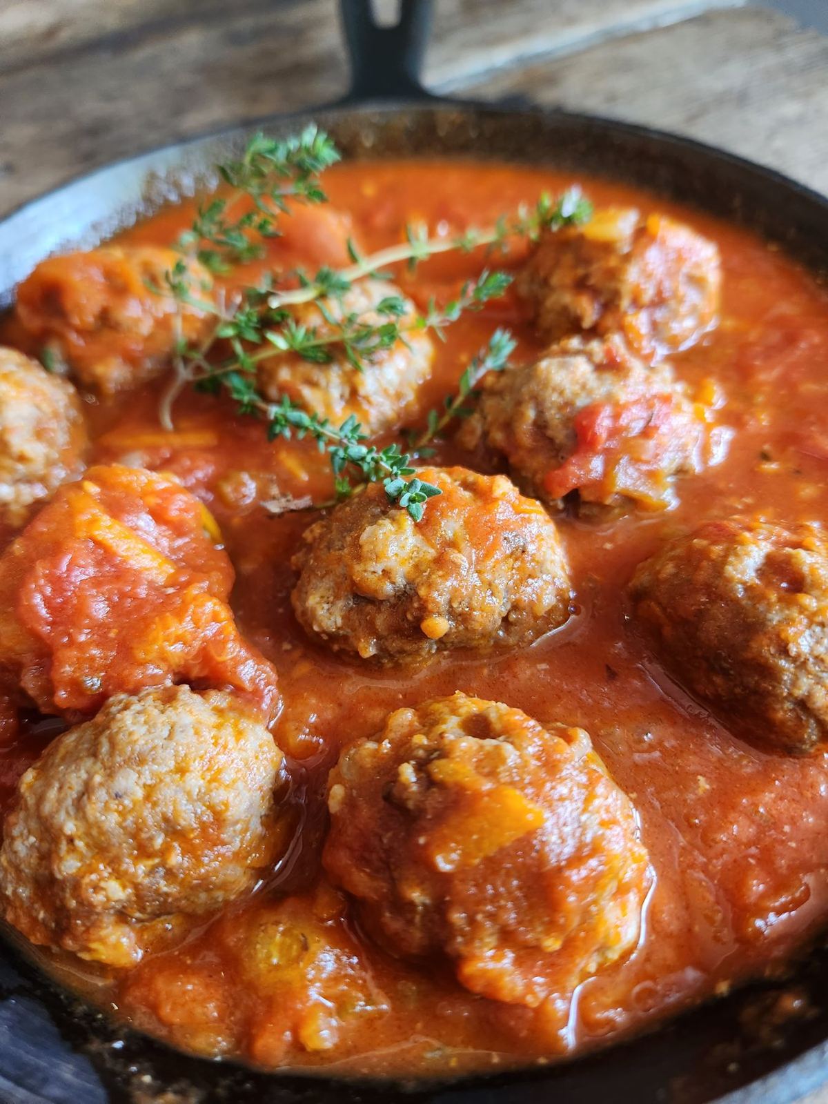 Meatballs in tomato sauce with thyme in a cast-iron pan